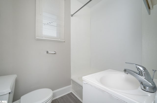 bathroom featuring a sink, toilet, baseboards, walk in shower, and wood finished floors