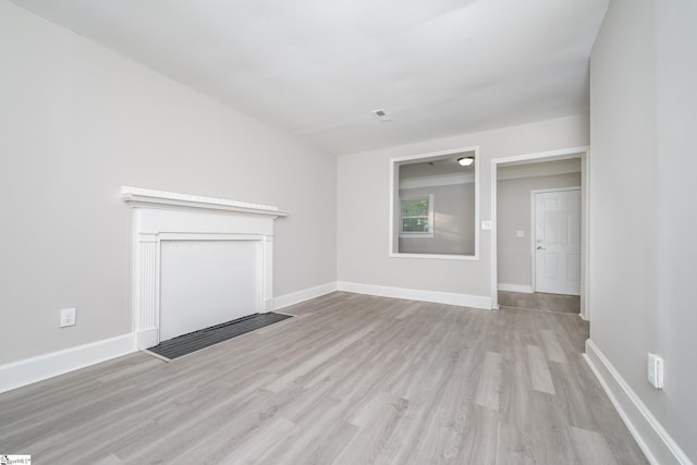 unfurnished living room with wood finished floors and baseboards