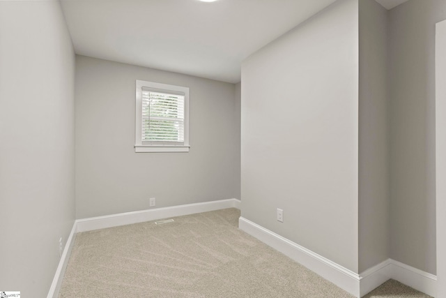 carpeted spare room featuring baseboards