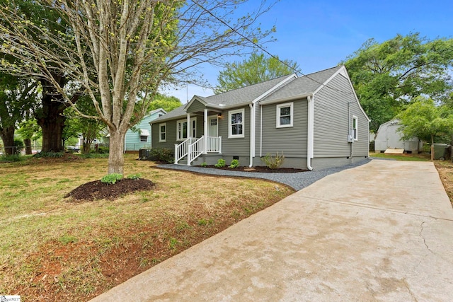 view of front facade featuring crawl space, roof with shingles, driveway, and a front yard