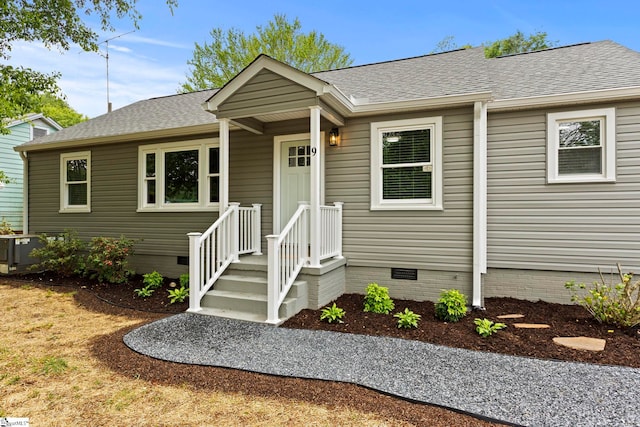 view of front of home with crawl space, a shingled roof, and central AC unit