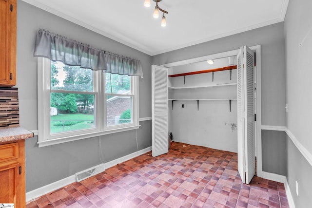 unfurnished bedroom featuring visible vents, baseboards, a closet, brick patterned floor, and ornamental molding