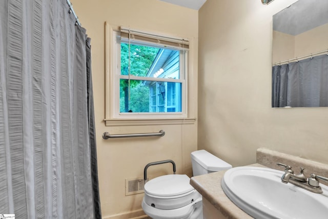 full bathroom with visible vents, a shower with shower curtain, toilet, and a sink