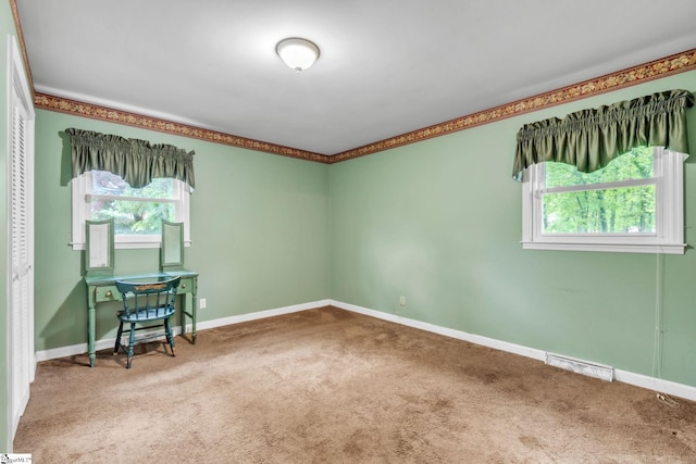 carpeted empty room featuring plenty of natural light and baseboards