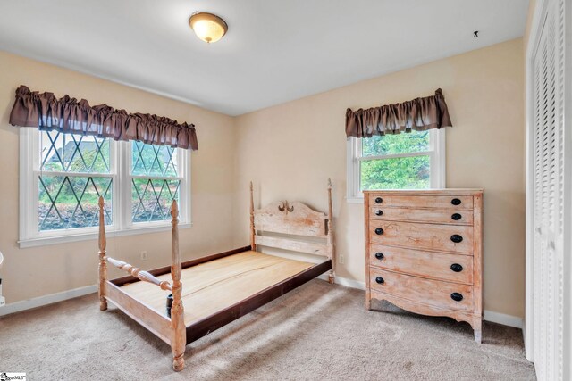bedroom featuring light colored carpet and baseboards