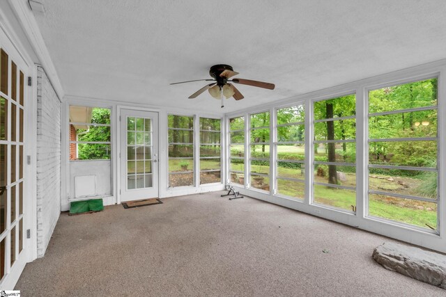 unfurnished sunroom with a healthy amount of sunlight, french doors, and a ceiling fan