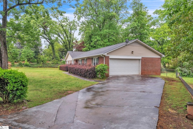 ranch-style house with brick siding, fence, driveway, a front yard, and an attached garage
