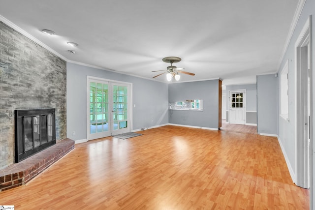 unfurnished living room with a brick fireplace, ornamental molding, ceiling fan, and light wood-style flooring