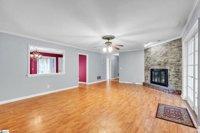 unfurnished living room featuring visible vents, wood finished floors, a large fireplace, and crown molding
