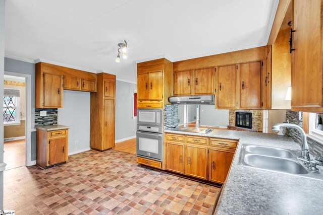 kitchen with decorative backsplash, electric cooktop, a sink, wall oven, and under cabinet range hood