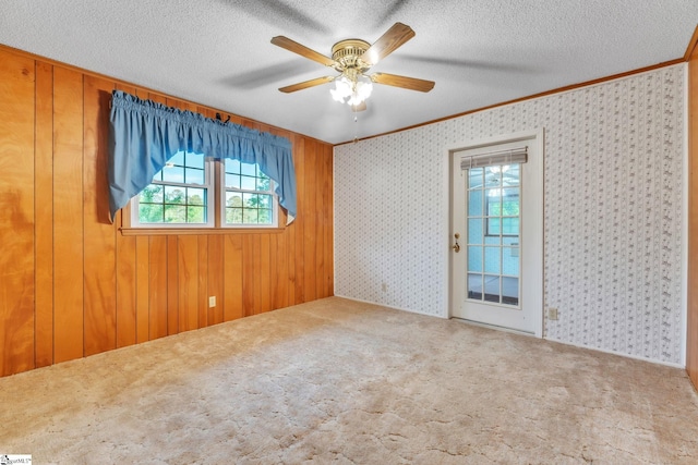 spare room with ornamental molding, a ceiling fan, and carpet flooring