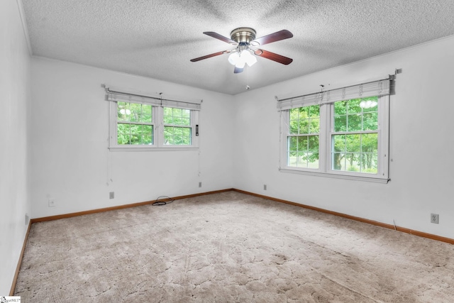 empty room featuring a textured ceiling, ceiling fan, carpet floors, and baseboards