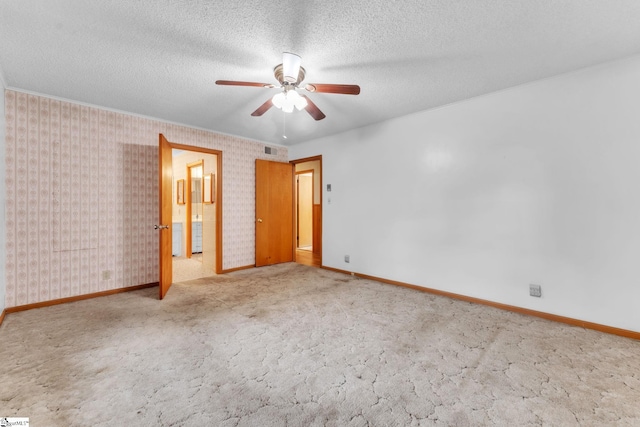 unfurnished bedroom with a textured ceiling, visible vents, and baseboards