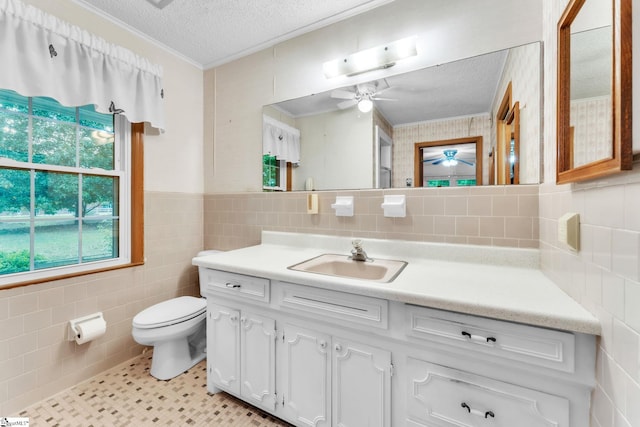 bathroom with toilet, tile walls, a ceiling fan, and a textured ceiling