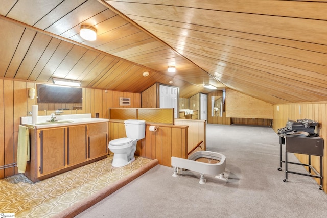 bathroom featuring lofted ceiling, wood walls, wooden ceiling, toilet, and vanity