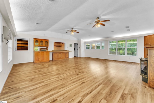 unfurnished living room with light wood-style floors, baseboards, a ceiling fan, a textured ceiling, and lofted ceiling