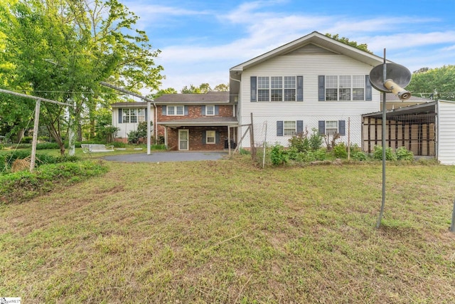 back of house featuring brick siding, a yard, and a patio area