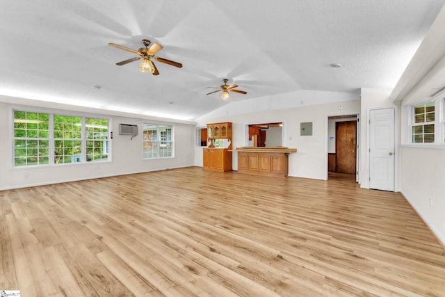unfurnished living room featuring ceiling fan, baseboards, vaulted ceiling, and light wood-style floors