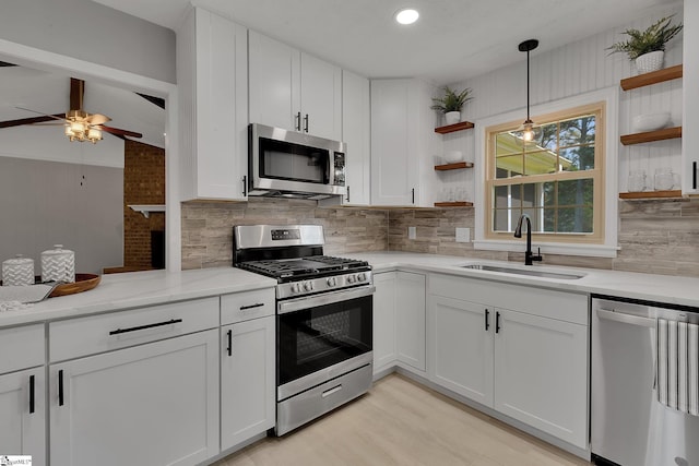 kitchen featuring tasteful backsplash, stainless steel appliances, open shelves, ceiling fan, and a sink