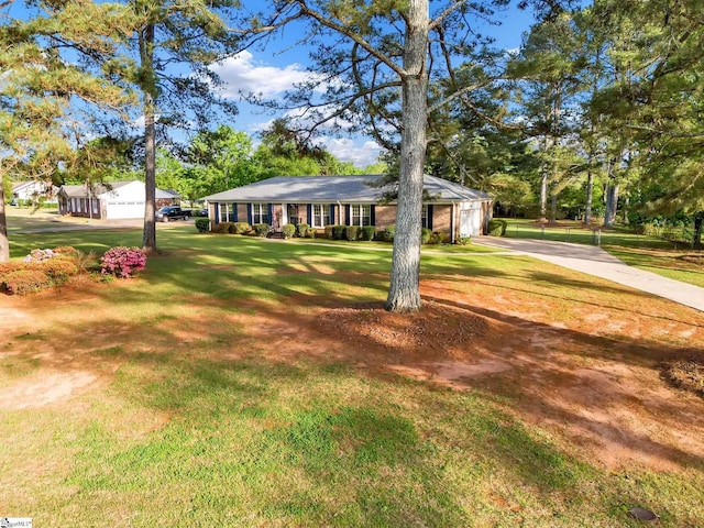 ranch-style house featuring a front yard, concrete driveway, and an attached garage