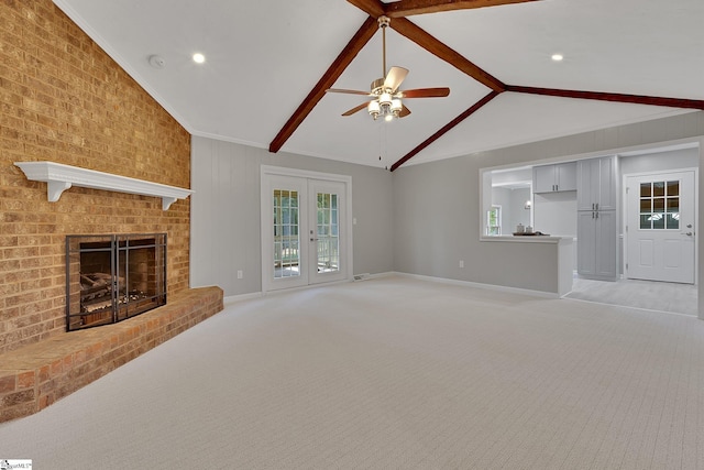 unfurnished living room featuring light colored carpet, a ceiling fan, vaulted ceiling with beams, and baseboards
