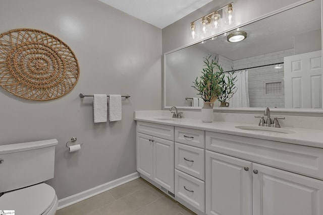 full bathroom with a sink, tile patterned floors, toilet, a tile shower, and baseboards