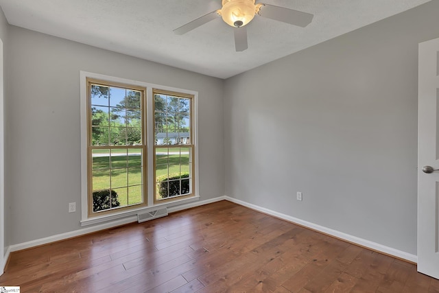 spare room featuring wood finished floors and baseboards