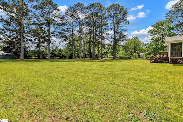view of yard with a deck and a sunroom