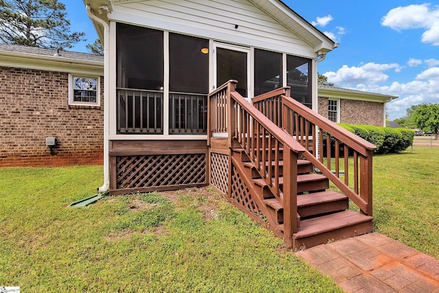 wooden deck featuring a sunroom, a yard, and stairway