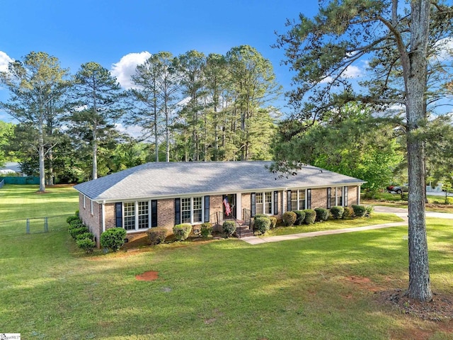 ranch-style house featuring a front yard, fence, and brick siding