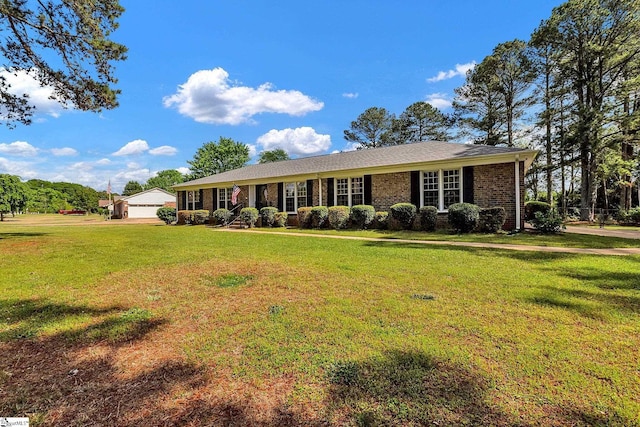 single story home with a detached garage, a front yard, and brick siding