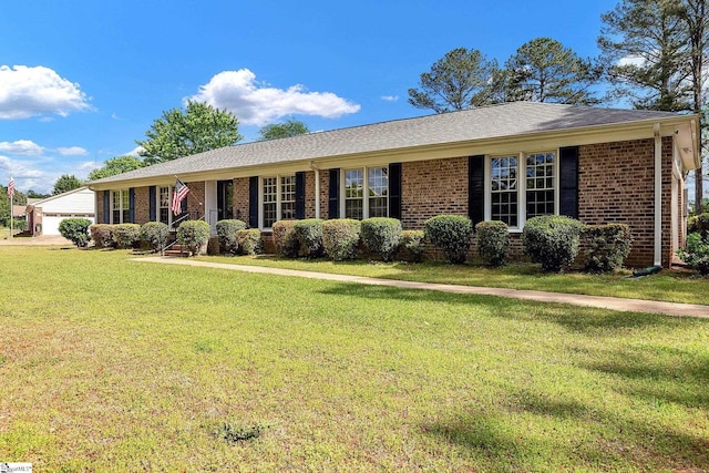 ranch-style home featuring a garage, brick siding, and a front yard