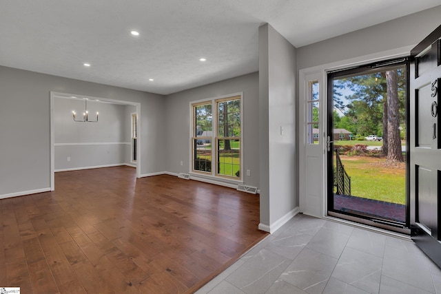 foyer with visible vents, recessed lighting, a notable chandelier, and baseboards