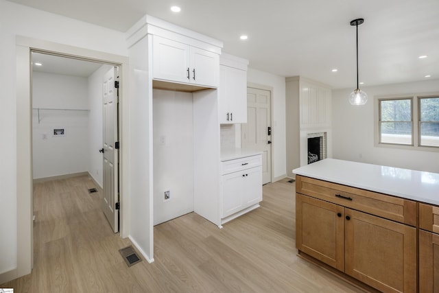 kitchen featuring recessed lighting, pendant lighting, light countertops, and light wood finished floors