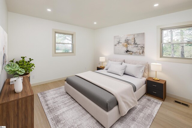 bedroom with light wood finished floors, visible vents, and multiple windows