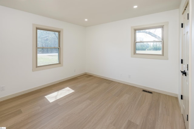spare room with plenty of natural light, light wood-style flooring, and baseboards