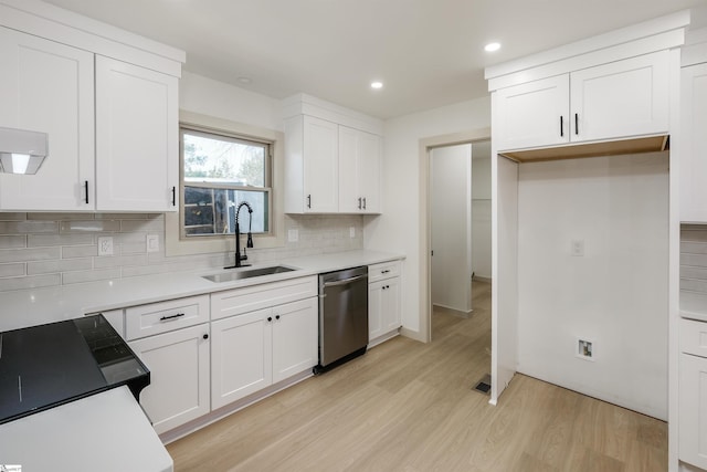 kitchen featuring a sink, light wood-style floors, white cabinetry, backsplash, and stainless steel dishwasher