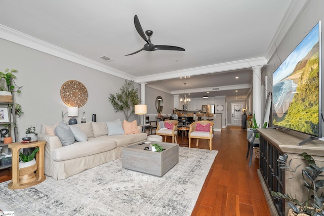 living area with ornate columns, visible vents, a ceiling fan, and ornamental molding