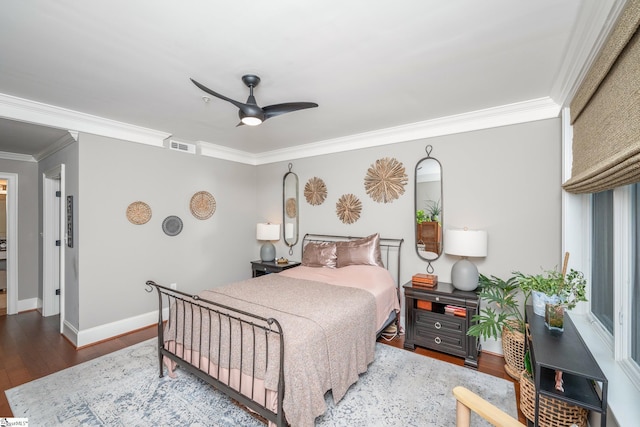 bedroom with crown molding, visible vents, baseboards, wood finished floors, and a ceiling fan