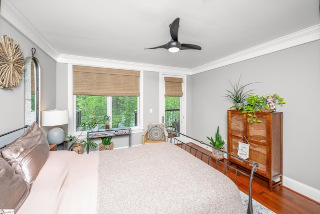 bedroom with baseboards, wood finished floors, a ceiling fan, and crown molding