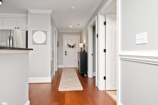 corridor featuring baseboards, recessed lighting, wood finished floors, and crown molding