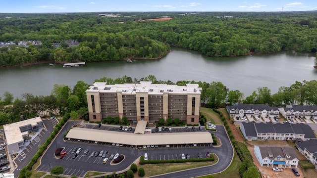 birds eye view of property with a wooded view and a water view