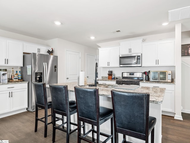 1087 Summerlin Trl, Duncan, SC 29334 - kitchen featuring dark wood finished floors, visible vents, stainless steel appliances, and white cabinetry