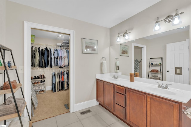 full bath with tile patterned floors, visible vents, double vanity, and a sink
