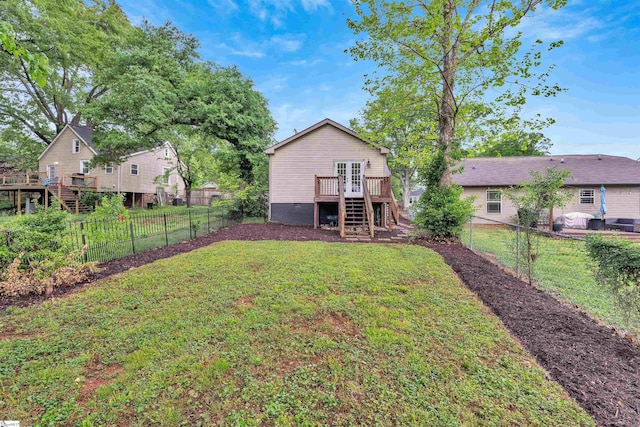 view of yard featuring stairs, french doors, a wooden deck, and a fenced backyard