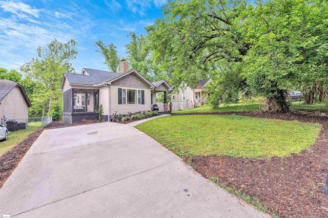 view of front of house with a chimney, fence, and a front yard