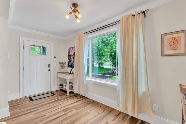 entrance foyer with light wood-type flooring, ornamental molding, and baseboards