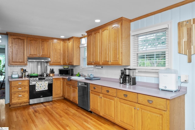 kitchen featuring decorative backsplash, light wood-style floors, stainless steel appliances, under cabinet range hood, and light countertops