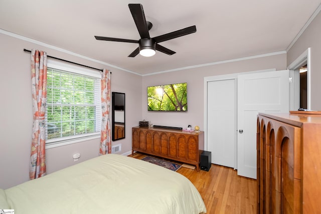 bedroom featuring visible vents, ornamental molding, and light wood-style floors