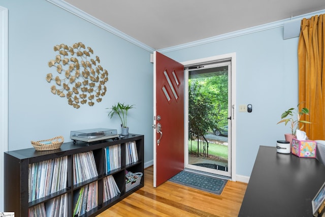 entryway featuring ornamental molding, wood finished floors, and baseboards